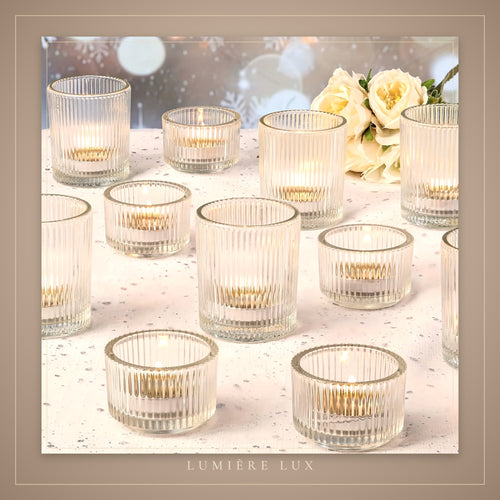 Crystal clear votive holders glowing on a white table